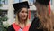 Two graduate students standing near university and talking about future career