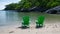 Two green beach chairs sitting on the rocks