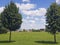 Two green canopies, symmetrical, in the park. Sunny day with clouds