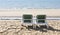 Two green deckchairs overlooking the sea