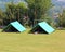 Two green explorer tents mounted by scouts