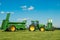 Two green John Deere tractors pulling bunning muck spreaders