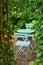 Two green metal chairs and table in a serene, peaceful private courtyard in a home backyard on a summer day. Small