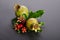 Two green pomegranates with leaves on gray background