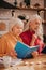 Two grey-haired pleasant cute ladies looking involved while studying together