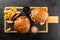Two grilled hamburgers and fries on a wooden board, ready to eat.