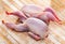 Two gutted quails prepared for cooking on wooden table