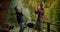 Two guys dance and have fun while cooking on the grill on a spacious balcony overlooking coniferous ice and mountains