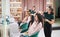 Two hairdressers styling women hair in beauty salon.