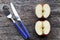 Two half apples and knife and fork on an old wooden table