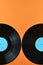 Two half black vinyl record on orange background