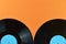 Two half black vinyl record on orange background