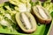 Two half juicy ripe kiwi fruit, fresh crisp lettuce on plate. Green background. Salad leaf. Organic healthy food. Detox diet