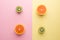 Two Half Orange and Two Half Kiwi on Geometry Yellow Pink Pastel Background, Top View.