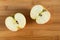 Two halves of an Apple on a wooden background. Top view