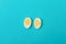 Two halves of a chicken egg with one yolk and three yolks on a blue background