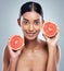 Two halves make on whole lotta goodness. Cropped portrait of an attractive young woman posing in studio against a grey