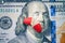 The two halves of the red pill lie on the Ben Franklin`s face of hundred-dollar bill.