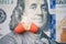 The two halves of the red pill lie on the Ben Franklin`s face of hundred-dollar bill.