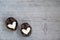 Two halves of split walnut with core in form of white hearts on wooden background. Concept of Valentine's Day and