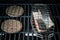 Two hamburger slices and salmon steak on grill rack