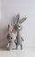 Two handmade gray rabbits crocheted on a white background