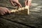 Two hands assembling a staircase of wooden pegs for the third on