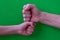 Two hands bumping fists on a green background