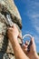 Two hands of climber fix equipment on rock