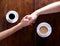 Two hands held together with cups of coffee