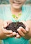 Two hands holding and caring a young green plant