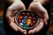 two hands holding different colored marbles near a bowl