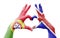 Two hands of a person painted with the flags of Portugal and the UK forming a heart