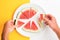 Two hands picking up sliced watermelon off a plate. Point of view of person eating