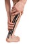 Two hands wrapped around the calf muscle of the right leg with a black kinesio tape pasted on, to relieve the load after sports