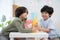 Two handsome boys sitting in the kindergarten school classroom and holding cup stacking looking at camera. Learning, enjoy,