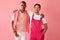 Two handsome diverse men in pink outfit posing isolated