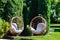 Two hanging chairs in garden on sunny summer day.