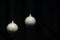Two hanging silver Christmas balls on dark background