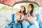 Two Happy Asian girls best friends traveler sit in Tuk Tuk taxi showing thumb up