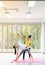 Two happy asian women in yoga poses in yoga studio with natural light setting scene / exercise concept / yoga practice / copy