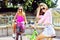 Two happy beautiful girls on a bicycles