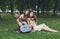 Two happy boho chic stylish girlfriends with guitar, picnic