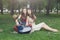 Two happy boho chic stylish girlfriends with guitar, picnic