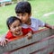 Two happy boys in society park, happy Asian brothers who are smiling happily together. Brothers play outdoors in summer, best