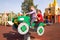 Two happy caucasian girls having fun on playground, swinging on a spring rocker