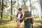 Two happy children having fun during forest hike on beautiful day in pine forest. Cute boy scout with binoculars during