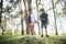 Two happy children having fun during forest hike on beautiful day in pine forest. Cute boy scout with binoculars during