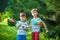 Two happy children playing in garden with windmill pinwheel. Adorable sibling brothers are best friends. Cute kid boy smile spring