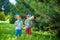 Two happy children playing in garden with windmill pinwheel. Adorable sibling brothers are best friends. Cute kid boy smile spring